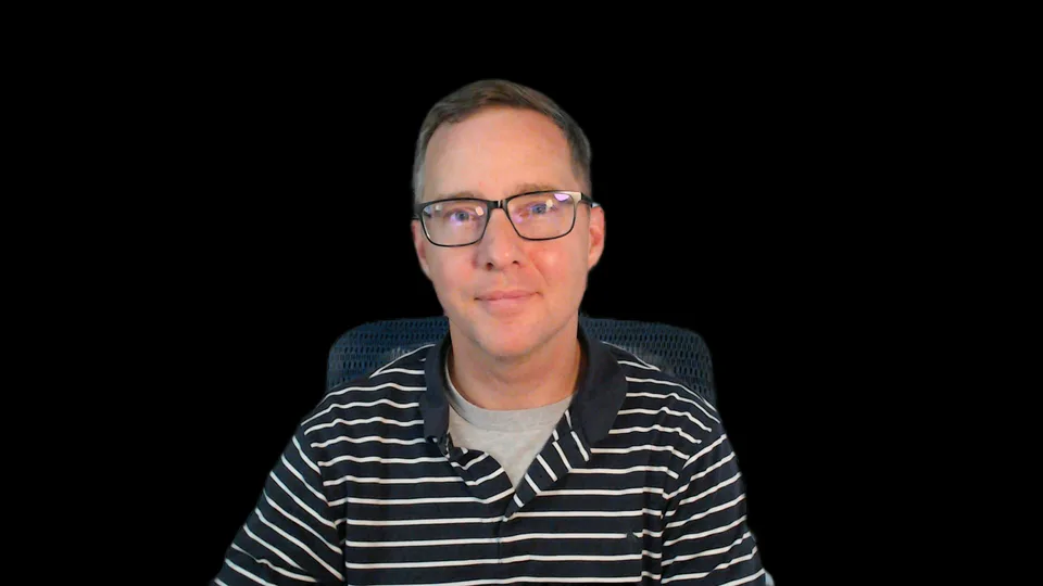 Photograph of Phillip J. Murphy wearing black glasses and a navy striped shirt